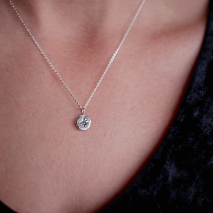 Silver necklace with a pendant on a person's neck