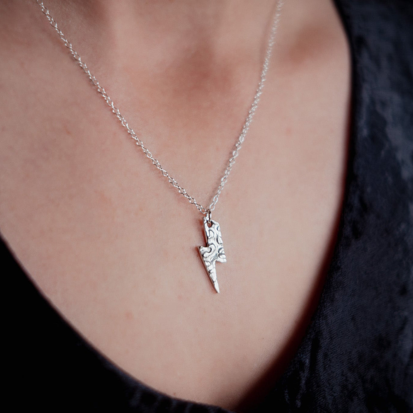 Silver necklace with a pendant worn by a person