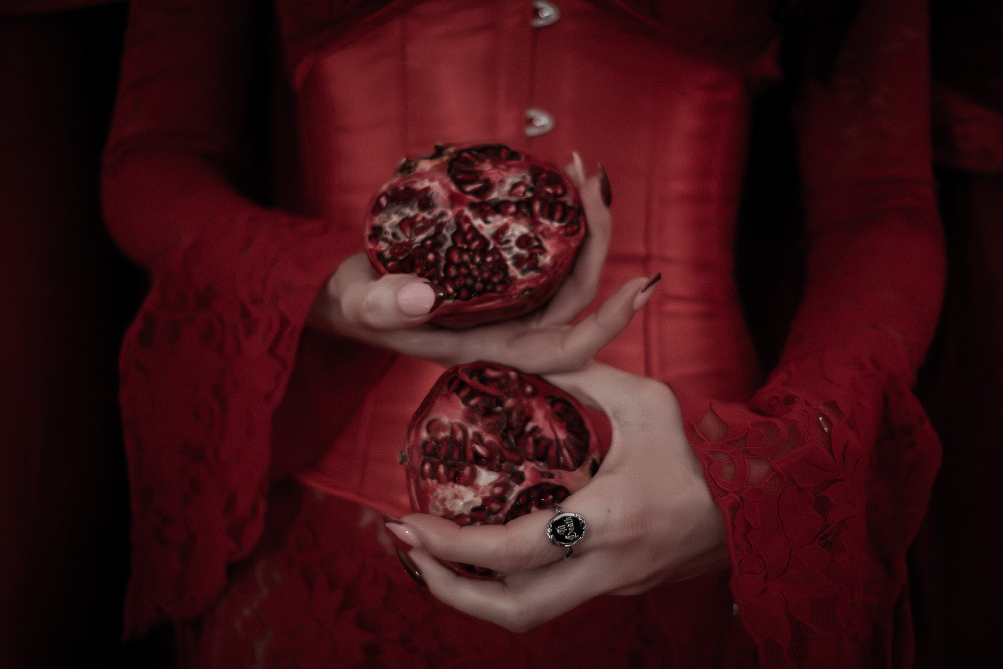 Girl holding pomegranate in red dress with til death silver ring
