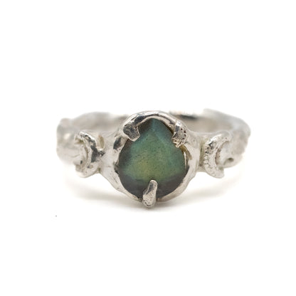 Silver moon ring with a green labradorite stone on a white background