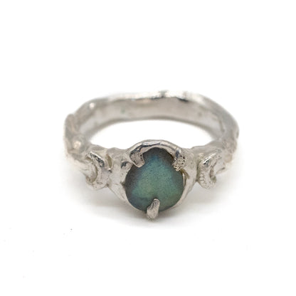 Silver moon ring with a green labradorite stone on a white background