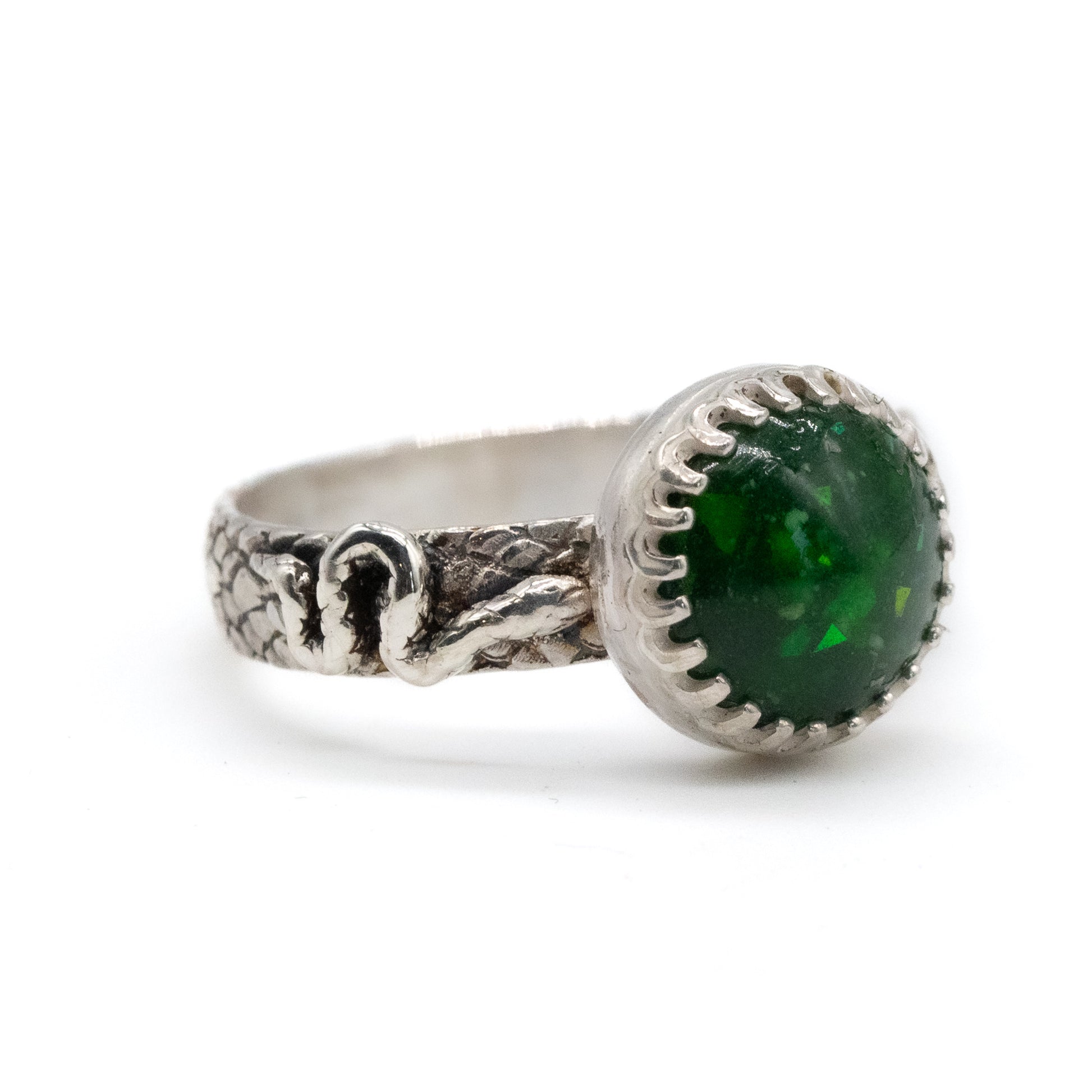 Silver breastmilk ring with a green gemstone on a white background