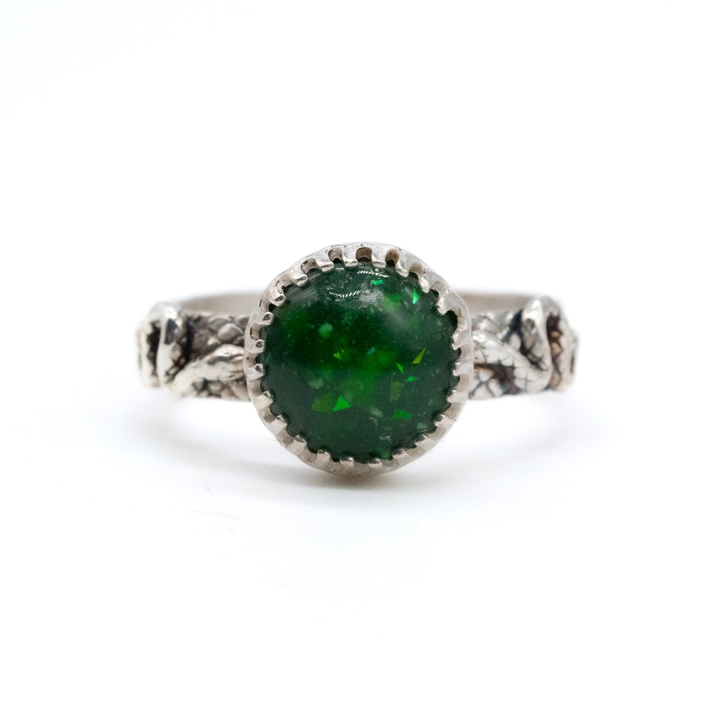 Silver breastmilk ring with a green gemstone on a white background