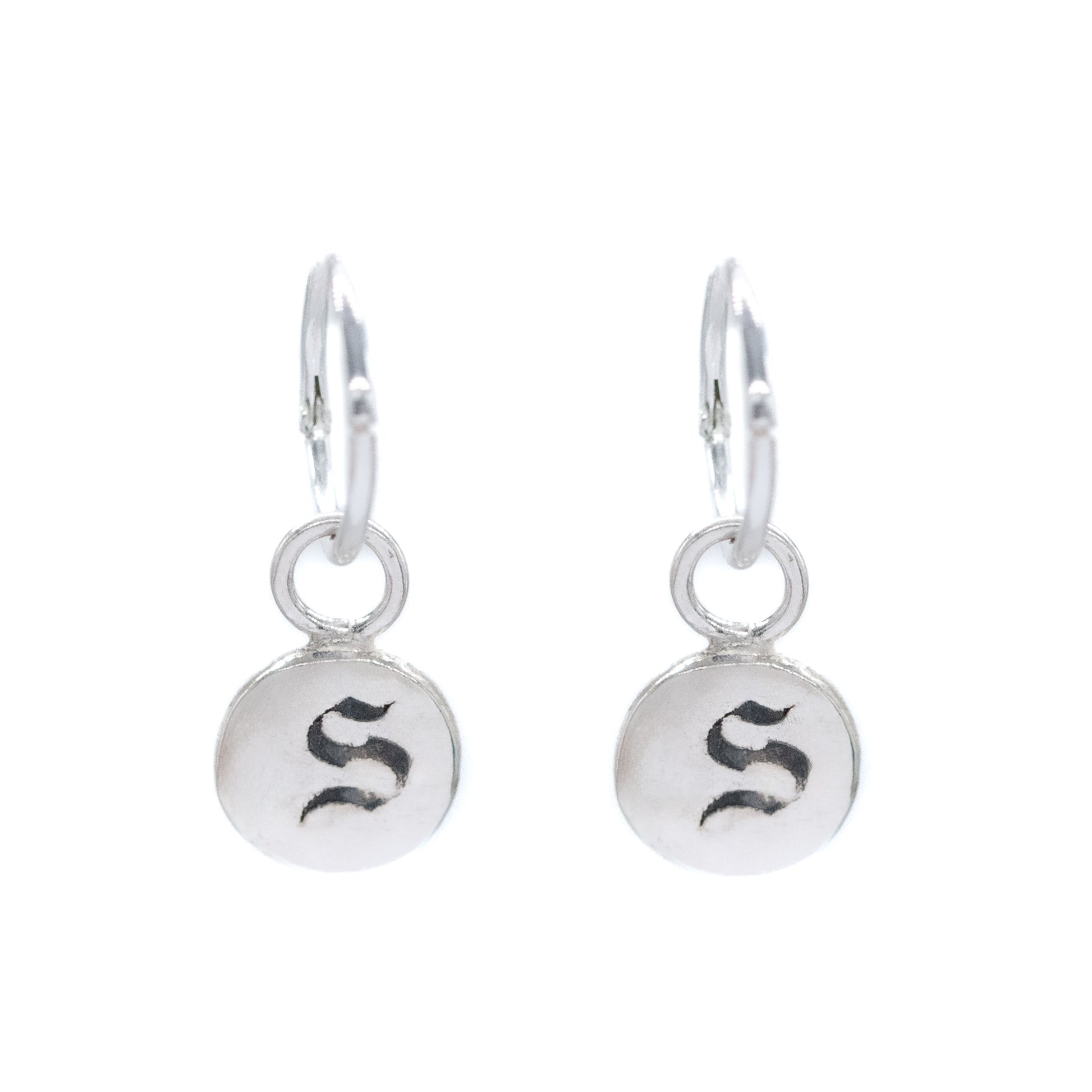 Pair of silver earrings with 'S' initials on a white background